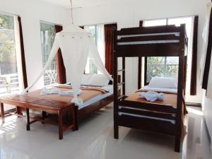a bedroom with two bunk beds and a swing at Bintang by Tobias Lodge Cafe & Restaurant in Kelimutu