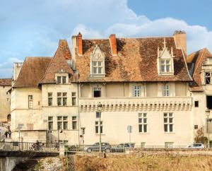 ein altes Gebäude mit einem Dach auf einer Brücke in der Unterkunft La Maison des Consuls in Périgueux