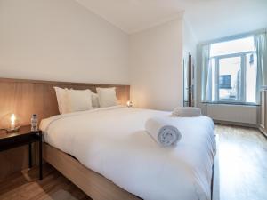 Schlafzimmer mit einem großen weißen Bett und einem Fenster in der Unterkunft Sweet Inn -Dansaert in Brüssel
