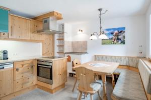 a kitchen with wooden cabinets and a wooden table at Haus Alpenblick in Oetz