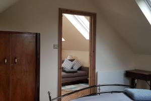a bedroom with a mirror and a bed and a chair at The Old School Loft in Blidworth