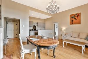 a kitchen and living room with a table and chairs at La Maison des Consuls in Périgueux