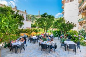 un groupe de personnes assises à table dans un restaurant dans l'établissement Hotel Leone, à Sorrente