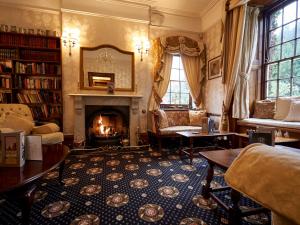 a living room with a fireplace and a fire place at Hempstead House Hotel & Restaurant in Sittingbourne