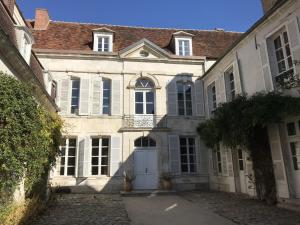 - un grand bâtiment blanc avec une porte et des fenêtres blanches dans l'établissement Saint-Eusèbe Mansion - Hôtel Particulier St-Eusèbe, à Auxerre