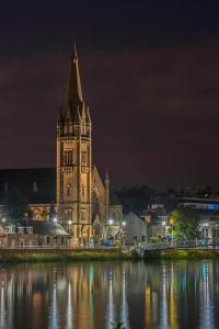 a church with a clock tower at night at Scardroy Homes Apartment Inverness in Inverness