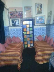 two beds in a room with colorful at RIAD DAR KADER chambre saumon in Marrakesh