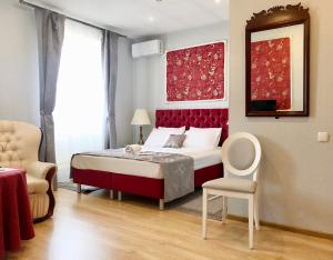 a bedroom with a bed with a red headboard and a chair at N-House Hotel in Moscow