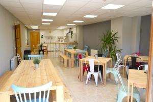un restaurante con mesas de madera y sillas en una habitación en Alda Estella Hostel, en Estella