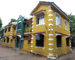 een geel gebouw met veel ramen aan een straat bij Rama Krishna Hotel in Mumbai
