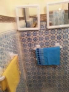 a bathroom with two mirrors and a blue towel at RIAD DAR KADER chambre saumon in Marrakesh