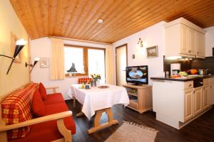 un salon avec un canapé rouge et une table dans l'établissement Landhaus Wild, à Riezlern