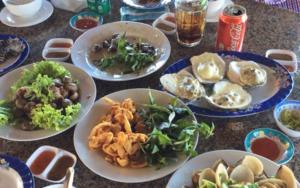 una mesa con platos de comida en una mesa en CocoPalm Villa near Beach - Coco Room, en Hội Mỹ
