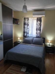 a bedroom with a bed and a window with curtains at Apartment ,,The Mall Athens" in Athens
