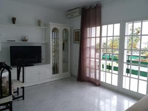 sala de estar con TV y puertas correderas de cristal en Casa Sardinero, en Torremolinos