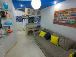ein Wohnzimmer mit einem Sofa und zwei gelben Kissen in der Unterkunft Costeira Praia Flat 204 in Natal