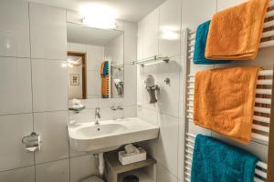 a bathroom with a sink and a mirror and towels at Haus Lucas Tschofen in Gaschurn