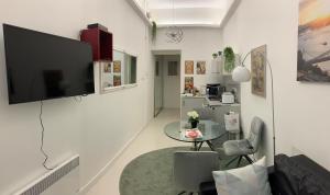 a living room with a table and a television on a wall at City Corso Apartman in Budapest