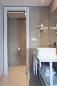 a bathroom with a sink, toilet and shower stall at Ryans La Marina in Ibiza Town