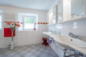 a white bathroom with two sinks and a window at Haus Alpenblick in Oetz +30 photos