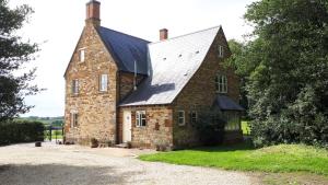 an old brick house with a metal roof at Cockley Hill Farm Bed & Breakfast in Brackley