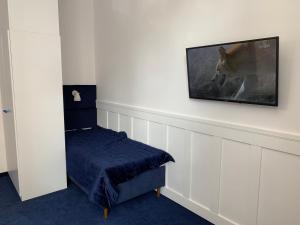 Pokój z telewizorem na ścianie z ławką w obiekcie Pokoj Pod Żaglami w mieście Gdynia