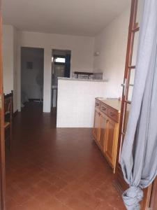 een woonkamer met een tegelvloer en een keuken bij Motel Logis d'Abartello in Olmeto