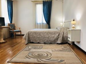 una camera con un letto e un tappeto su un pavimento in legno di Villamoreno a Merlara