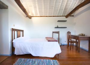 a bedroom with a bed and a table and a desk at Casa Rotas a Nordeste in Nordeste