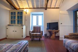 a living room with a chair and a flat screen tv at Casa Rotas a Nordeste in Nordeste