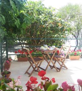 una mesa y sillas en un patio con flores en A casa di Nonna Rosa, en Lecce