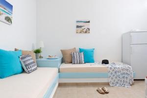 ein Wohnzimmer mit blauen und weißen Kissen und einer Couch in der Unterkunft Ferma Hill Apartments in Ferma