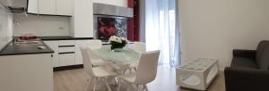 a kitchen with a table and white chairs in a room at Space Apartment in Cagliari