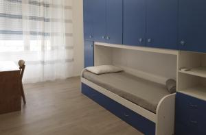 a small bedroom with blue cabinets and a bed at Space Apartment in Cagliari