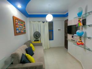 a living room with a couch and a tv at Costeira Praia Flat 204 in Natal