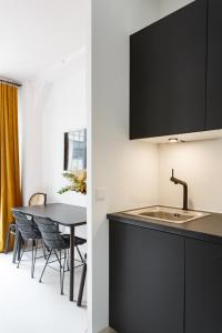 a kitchen with a sink and a table with chairs at Beaumarchais in Paris