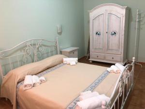 a bedroom with two beds with towels and a cabinet at Sa Corti Antiga Apartment in SantʼAntìoco