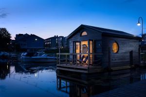 a small wooden house on the water at night at Jokimaja Alma in Porvoo