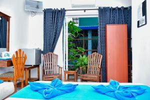 1 dormitorio con 1 cama, mesa y sillas en Nebula Residence, en Negombo