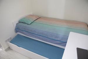 małe łóżko w białym pokoju z: w obiekcie Studio Tour Eiffel w Paryżu