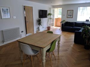 een woonkamer met een houten tafel en stoelen bij Helford Cottage in Gweek