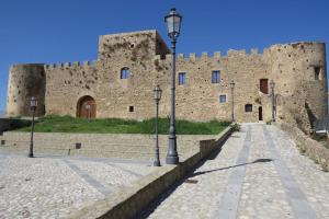 un viejo castillo con dos luces de la calle delante de él en BORGO PETELIA, "Casa Perri", antica casa ristrutturata con terrazzo, en Strongoli