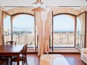 un soggiorno con tavolo e due grandi finestre di Residenze al Castello Apartments a Cagliari