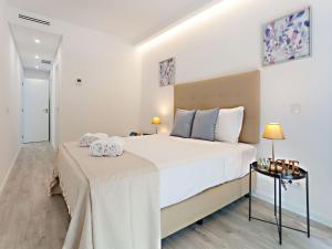 a bedroom with a large bed and a table at Faro Clara Suites in Faro