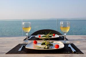uma mesa com dois pratos de comida e taças de vinho em Casa del Mar em Mpoukaris