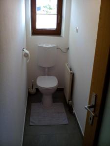 a small bathroom with a toilet with a window at Beilelers Hof in Arzl im Pitztal +11 photos