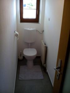 a small bathroom with a toilet with a window at Beilelers Hof in Arzl im Pitztal