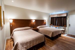 una habitación de hotel con 2 camas en una habitación en Motel Mistral, en Rouyn