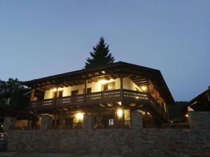 a log home with a deck at night at Слънчевата къща in Kovačevica