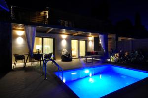 - une piscine dans un jardin la nuit dans l'établissement Casa del Mar, à Mpoukaris